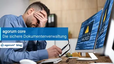 Ein Mitarbeiter mit Kopfschmerzen blickt auf einen gehackten Computer. Datenverlust und Sicherheitslücken bedrohen die Geschäftsprozesse und die Digitalisierung im Unternehmen.