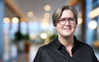 Jeannette Krause, Personalreferentin bei agorum, steht in einem modernen Büro mit unscharfem Hintergrund.