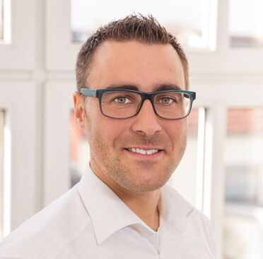 Porträtfoto von Herrn Schändlinger, einem Partner der BES Cloudplattform, im weißen Hemd vor einem Fenster.