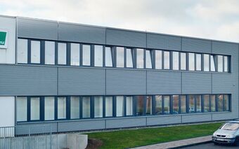 Das Bechtle IT-Systemhaus in Solingen zeigt ein modernes Gebäude mit mehreren Parkplätzen und dem Bechtle-Logo am Eingang.